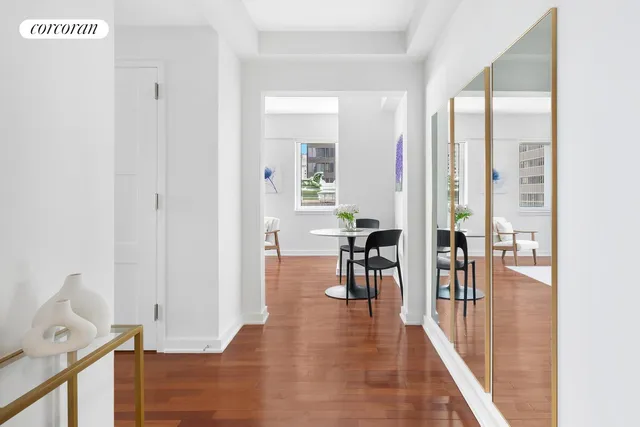 a view of a hallway with wooden floor and furniture