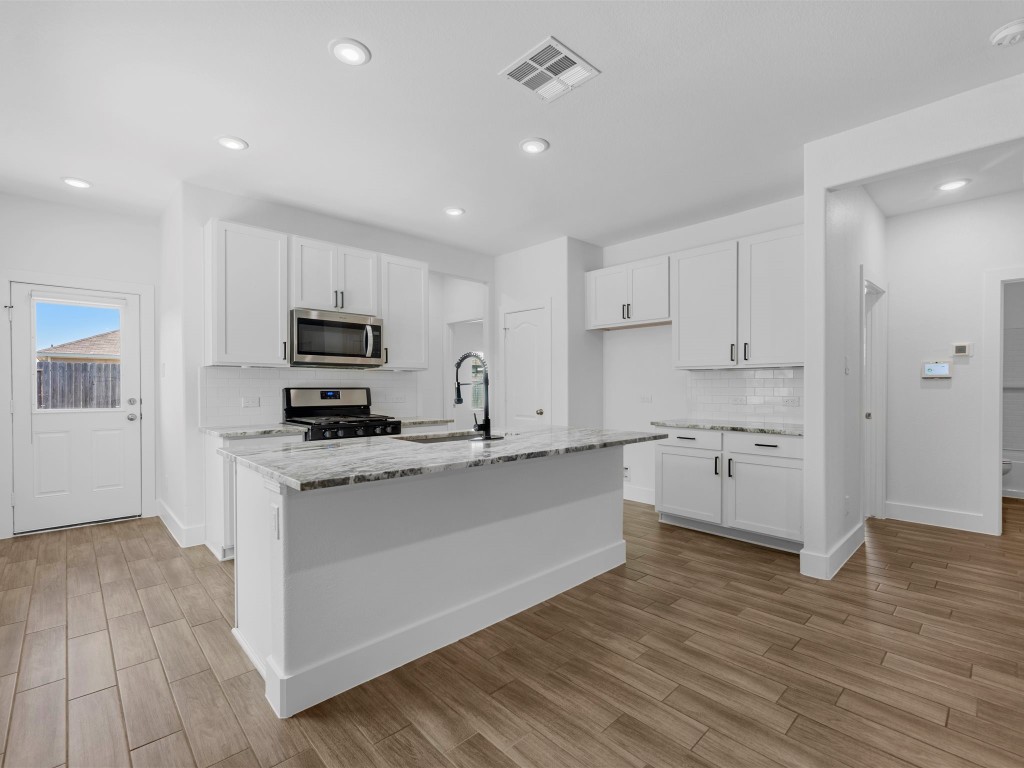 24751 Russet Bluff Trail Houston, TX 77336 - Photo 11 of 26 a kitchen with stainless steel appliances a sink a stove a microwave and cabinets