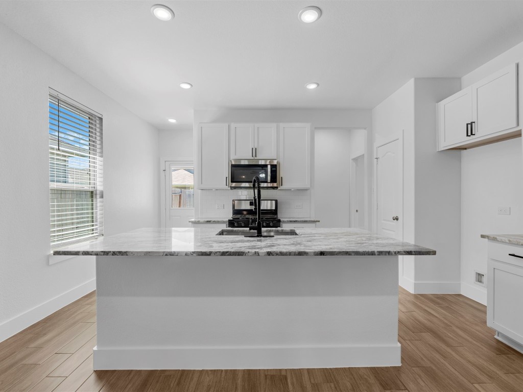 24751 Russet Bluff Trail Houston, TX 77336 - Photo 10 of 26 a kitchen with kitchen island granite countertop a stove and a sink