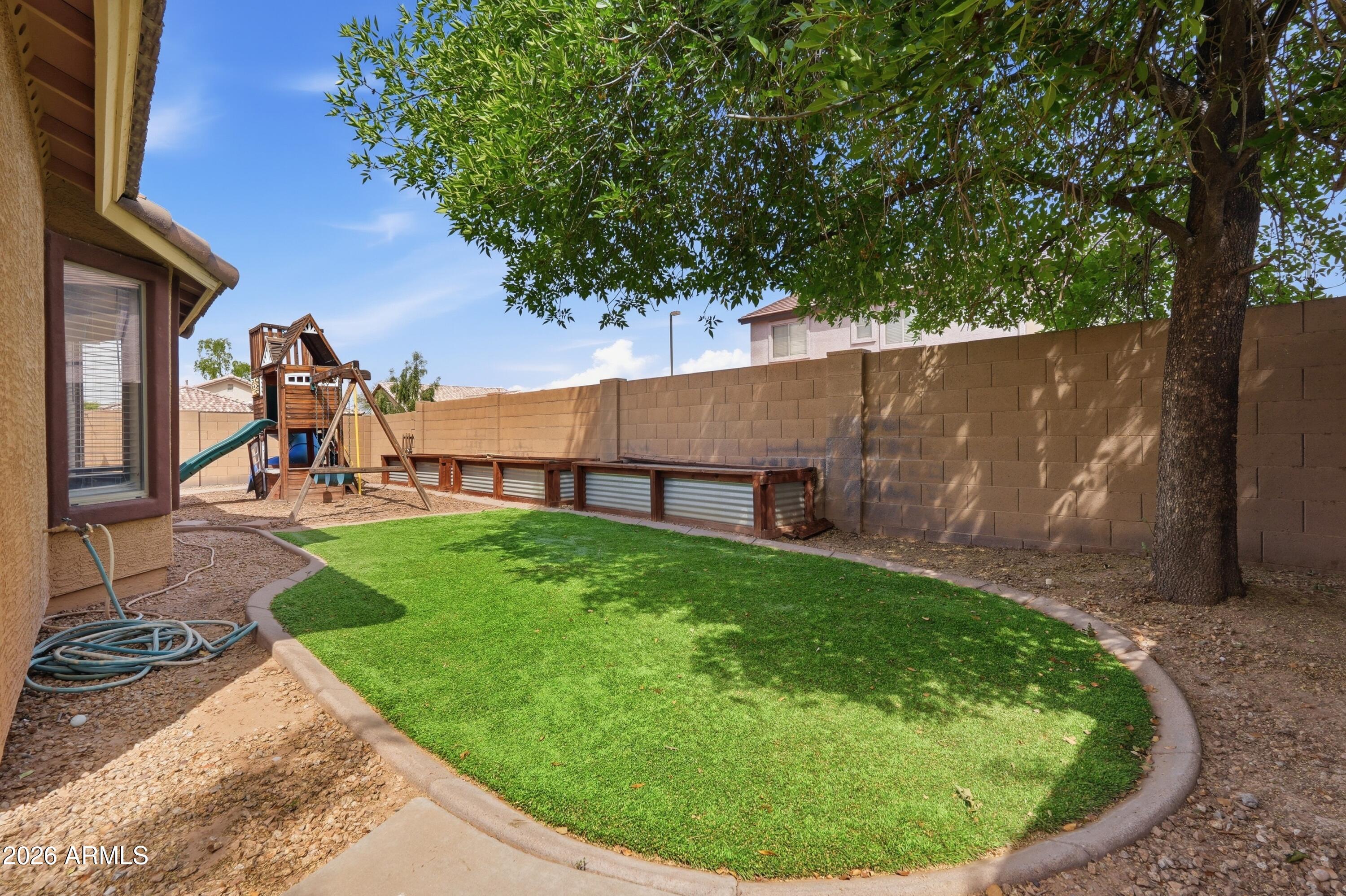 3242 East Bonanza Road Gilbert, AZ 85297 - Photo 33 of 36 a view of a backyard with plants and a slide