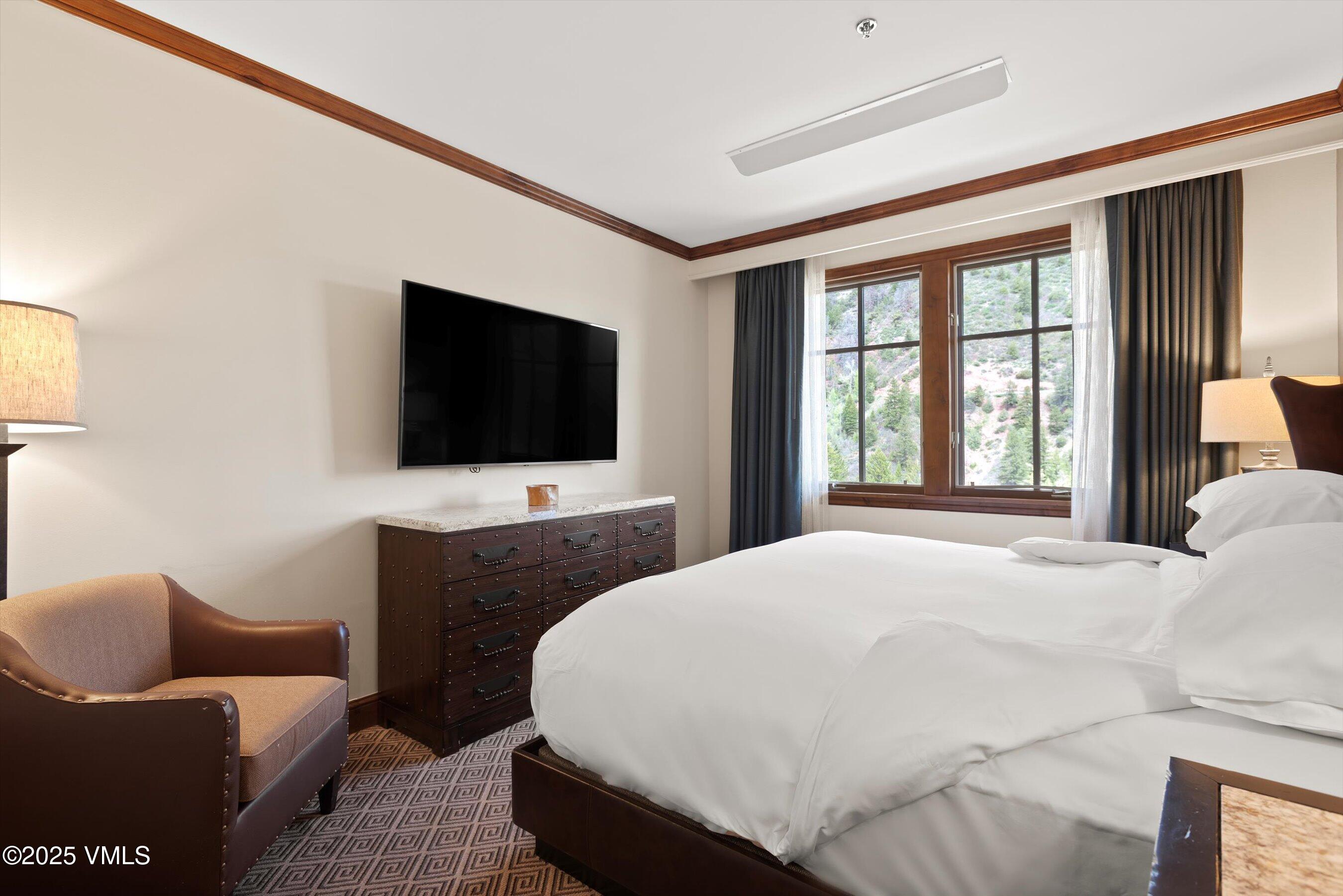 39 Boomerang Road, Unit 841114 Aspen, CO 81611 - Photo 20 of 35 a bedroom with a bed and a flat screen tv