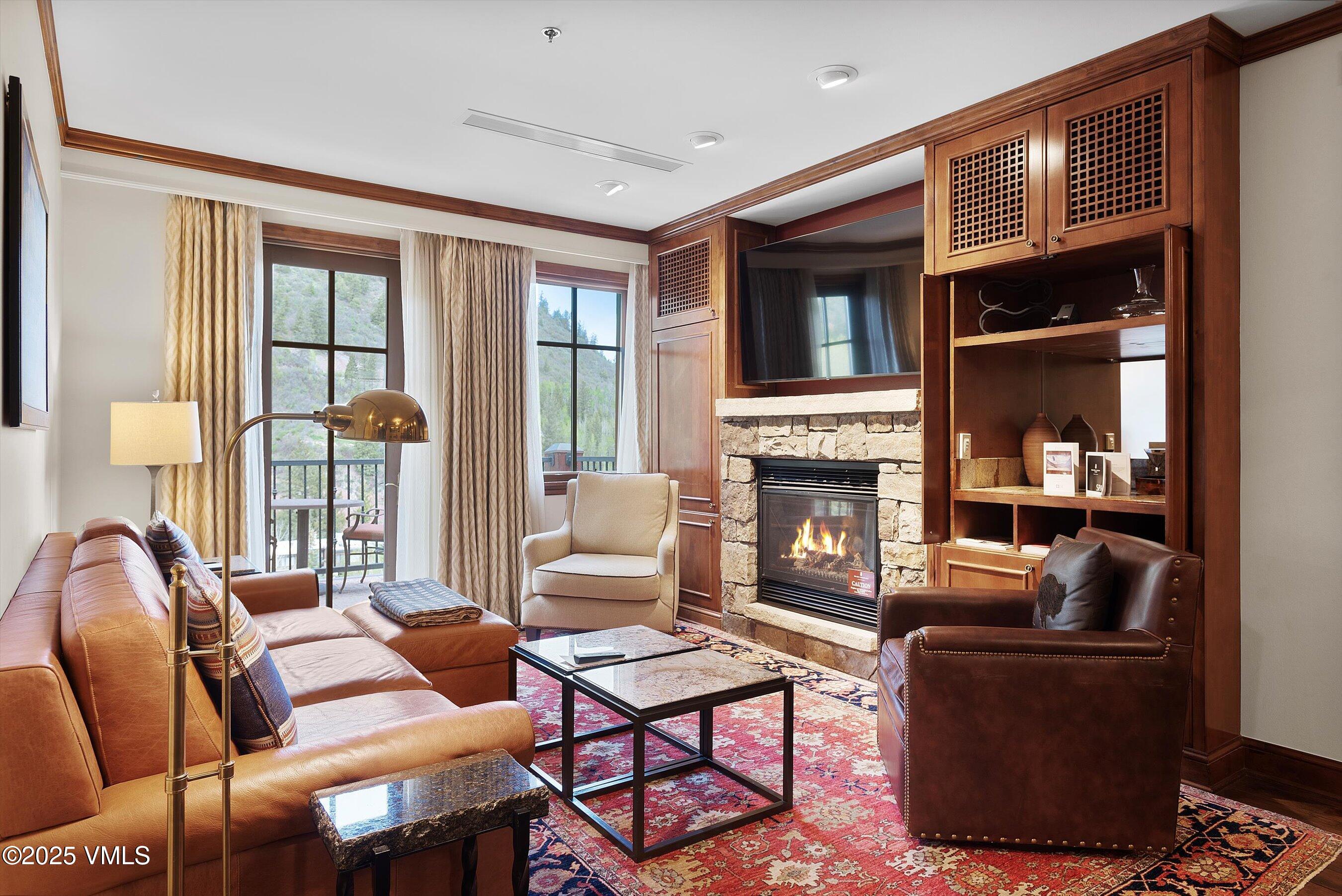 39 Boomerang Road, Unit 841114 Aspen, CO 81611 - Photo 6 of 35 a living room with furniture a fireplace and large window
