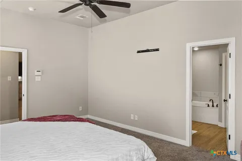 a bedroom with a bed and a ceiling fan