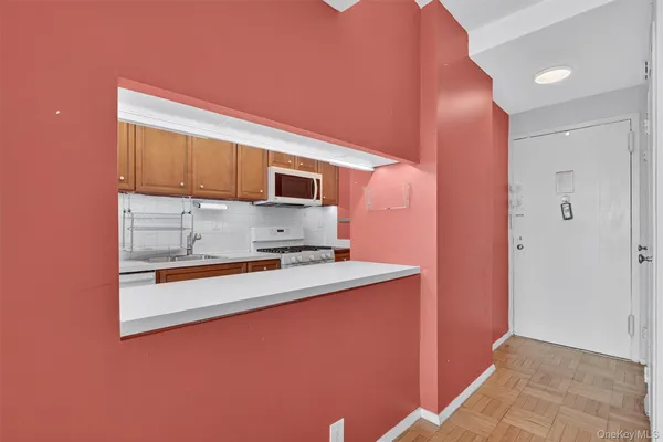 a kitchen with stainless steel appliances a microwave a stove and white cabinets