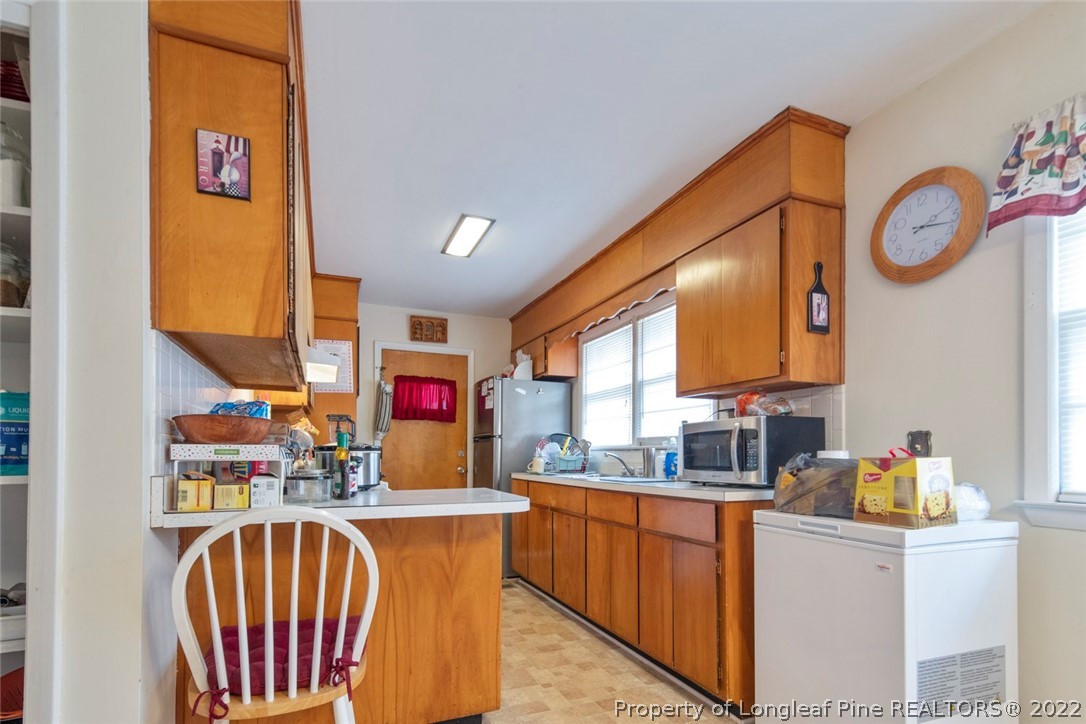 418 Pine Lake Park Road Pembroke, NC 28372 - Photo 8 of 19 a kitchen with stainless steel appliances granite countertop a sink dishwasher and a refrigerator with wooden floor