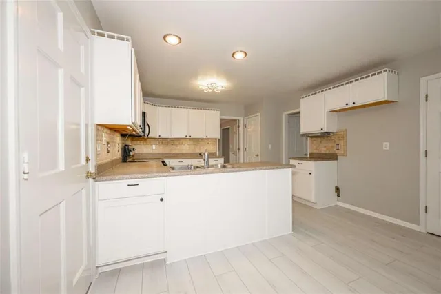 a kitchen with microwave a stove and cabinets