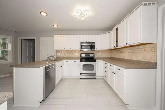 a stove top oven sitting inside of a kitchen