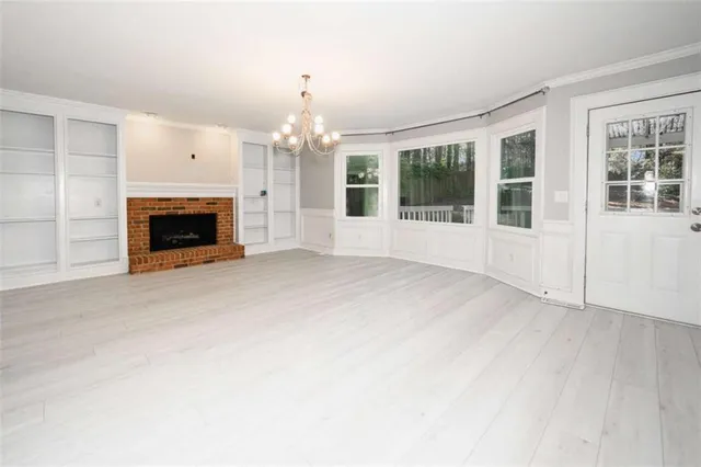 wooden floor fireplace and windows in an empty room