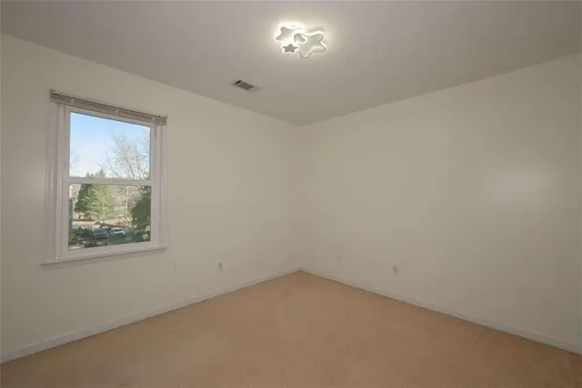 a view of a white house with large windows and a small yard