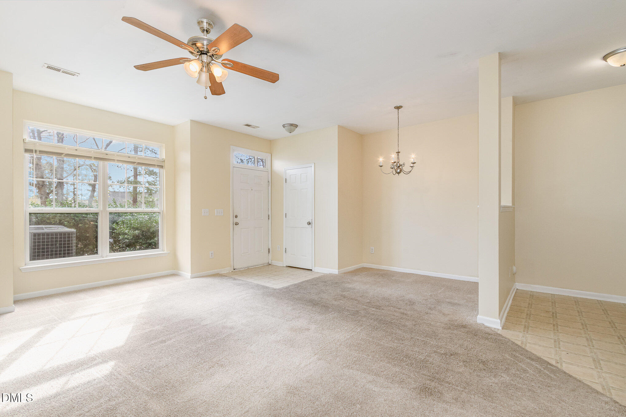 1311 Canyon Rock Court, Unit U105 Raleigh, NC 27610 - Photo 2 of 16 an empty room with chandelier fan and windows