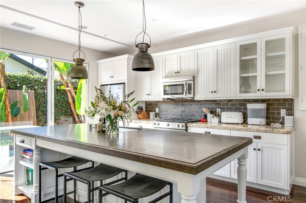 225 16th Place Costa Mesa, CA 92627 - Photo 2 of 43 a kitchen with stainless steel appliances granite countertop a sink a stove and a wooden cabinets
