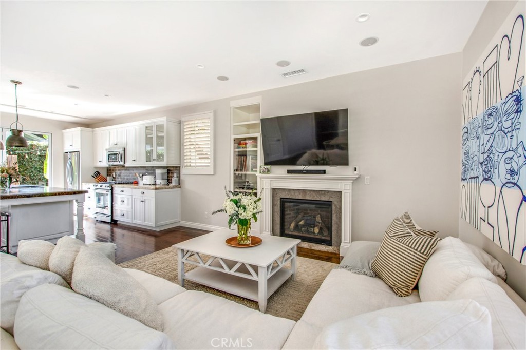 225 16th Place Costa Mesa, CA 92627 - Photo 24 of 43 a living room with furniture a flat screen tv and a fireplace