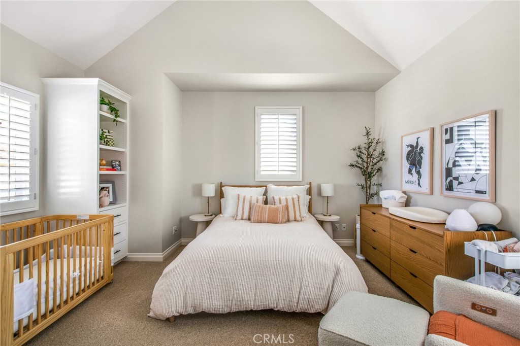 225 16th Place Costa Mesa, CA 92627 - Photo 28 of 43 a bedroom with a bed and a chandelier