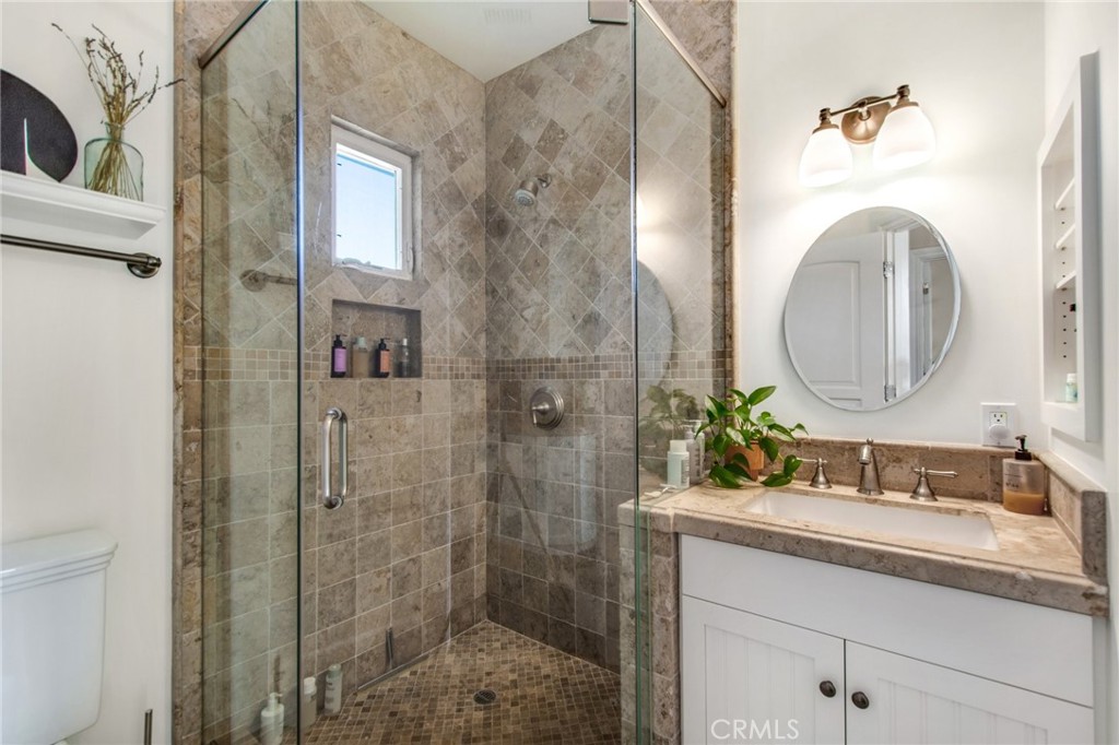 225 16th Place Costa Mesa, CA 92627 - Photo 30 of 43 a bathroom with a granite countertop sink a mirror and shower