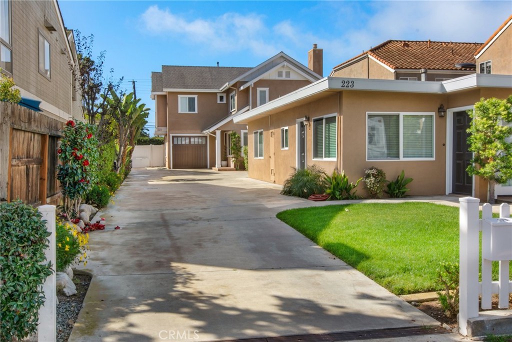 225 16th Place Costa Mesa, CA 92627 - Photo 33 of 43 a front view of a house with a garden and yard
