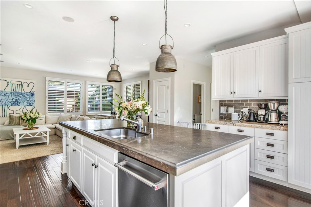 225 16th Place Costa Mesa, CA 92627 - Photo 4 of 43 a kitchen with stainless steel appliances granite countertop a sink a stove and a wooden floor
