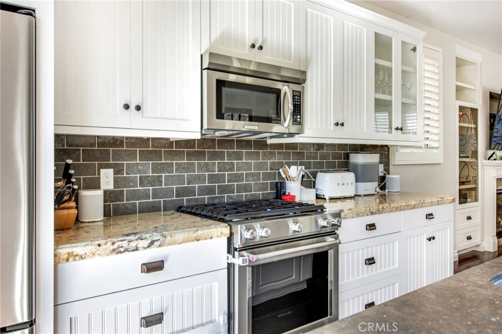 225 16th Place Costa Mesa, CA 92627 - Photo 6 of 43 a kitchen with stainless steel appliances granite countertop a stove and a microwave