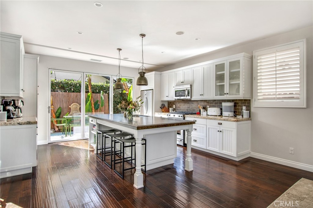 225 16th Place Costa Mesa, CA 92627 - Photo 8 of 43 a kitchen with stainless steel appliances granite countertop a stove a sink dishwasher a refrigerator with wooden floor
