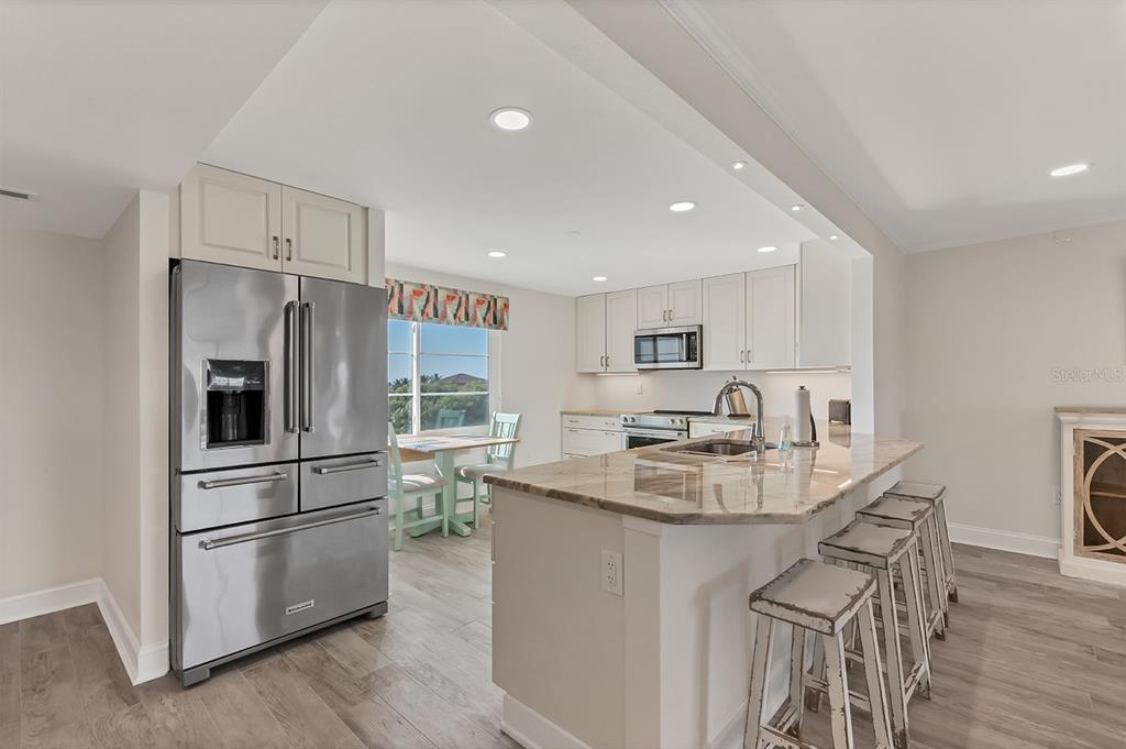 9397 Midnight Pass Road, Unit 501 Sarasota, FL 34242 - Photo 12 of 45 a kitchen with kitchen island a large counter top space appliances and center island