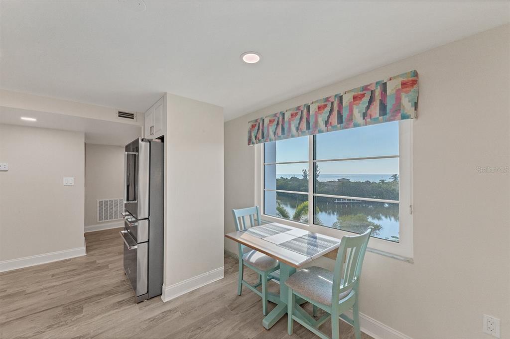 9397 Midnight Pass Road, Unit 501 Sarasota, FL 34242 - Photo 14 of 45 a view of a dining room with furniture and wooden floor