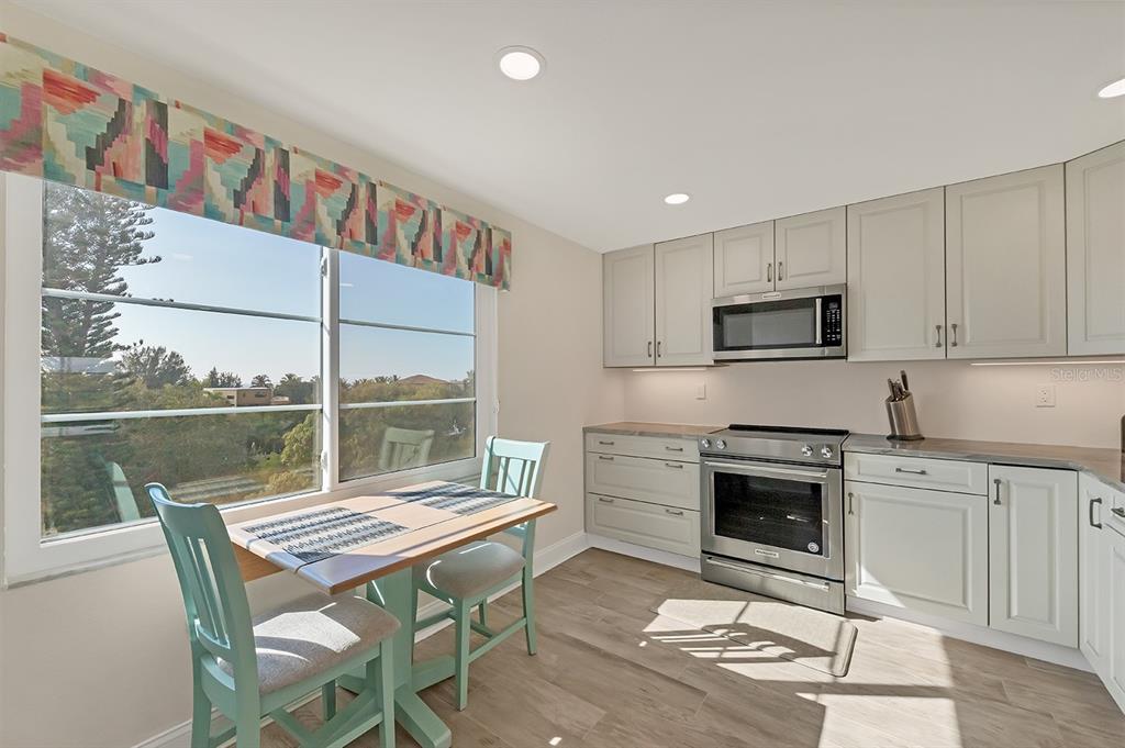 9397 Midnight Pass Road, Unit 501 Sarasota, FL 34242 - Photo 15 of 45 a kitchen with a stove a sink and a refrigerator