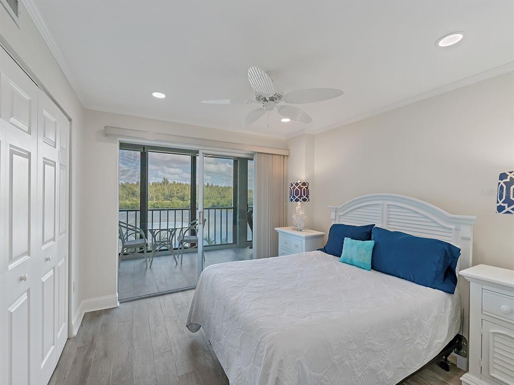 9397 Midnight Pass Road, Unit 501 Sarasota, FL 34242 - Photo 18 of 45 a bedroom with a large bed and a balcony view