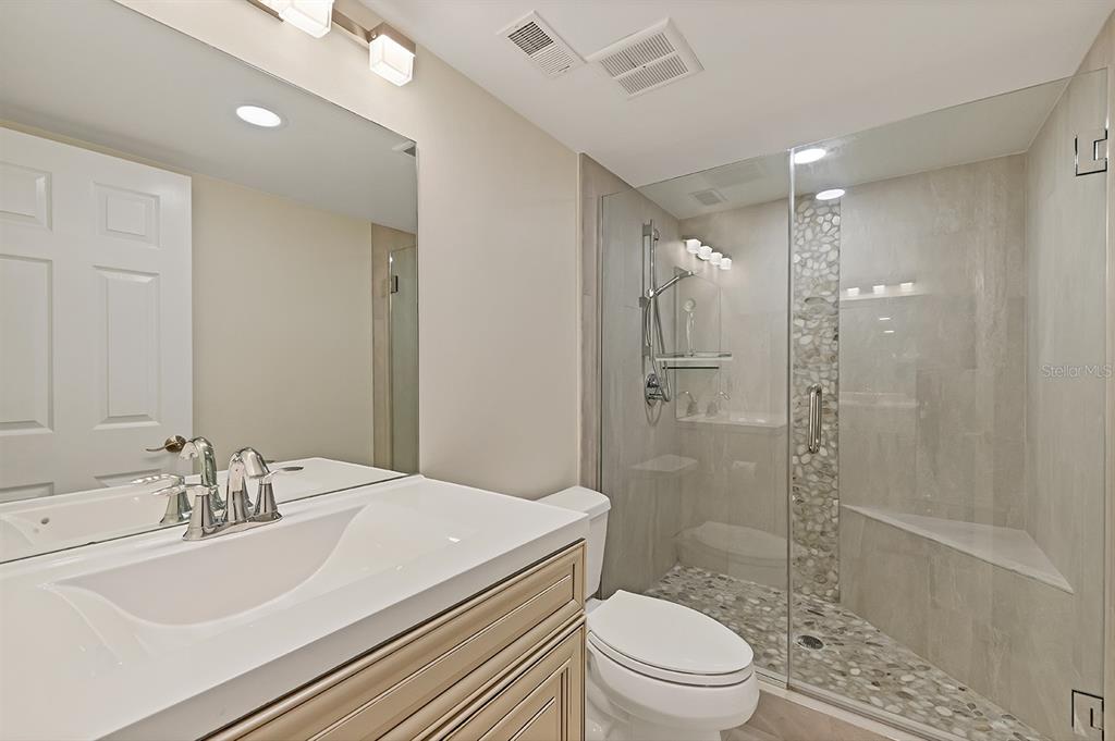 9397 Midnight Pass Road, Unit 501 Sarasota, FL 34242 - Photo 20 of 45 a bathroom with a sink a toilet and shower