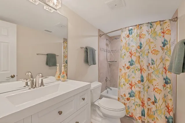 a bathroom with a sink toilet a mirror a shower and a tub