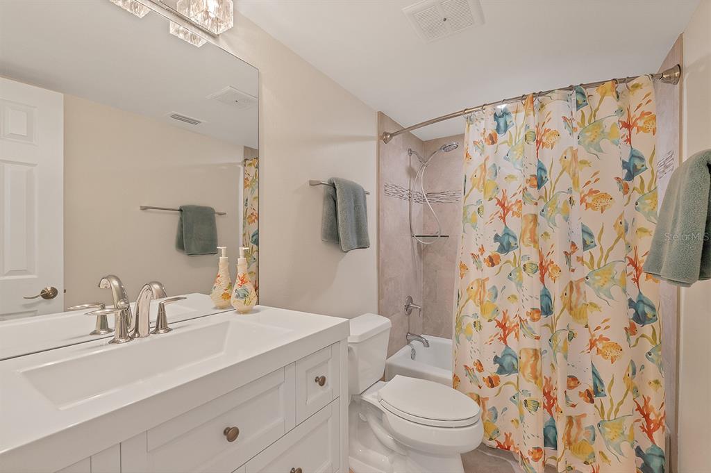 9397 Midnight Pass Road, Unit 501 Sarasota, FL 34242 - Photo 23 of 45 a bathroom with a sink toilet a mirror a shower and a tub