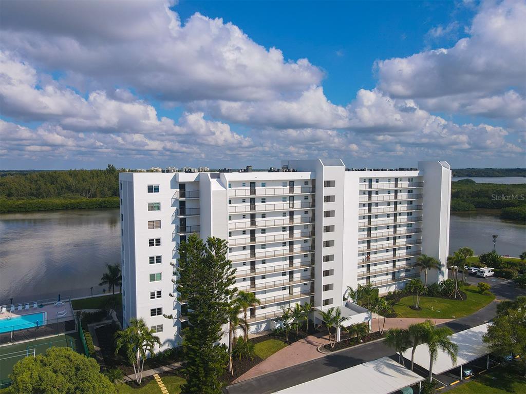 9397 Midnight Pass Road, Unit 501 Sarasota, FL 34242 - Photo 36 of 45 a view of a lake with a table and chairs next to a yard