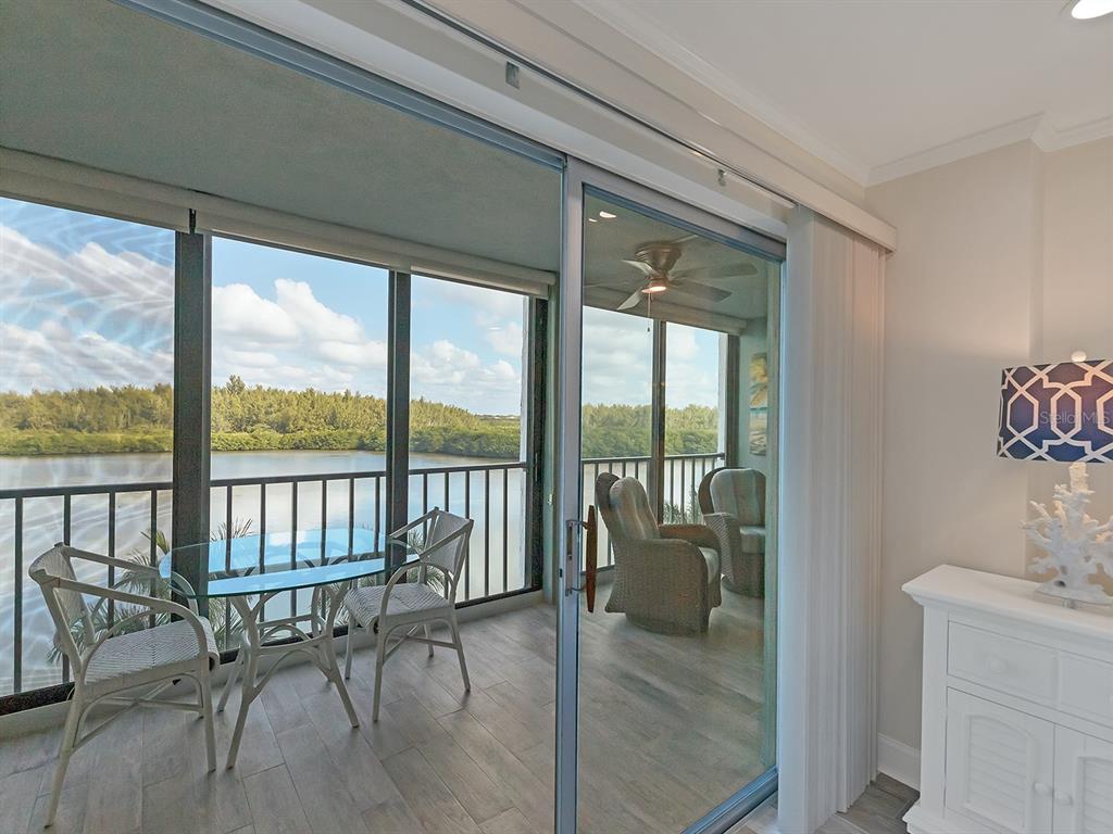 9397 Midnight Pass Road, Unit 501 Sarasota, FL 34242 - Photo 4 of 45 a balcony with table and chairs