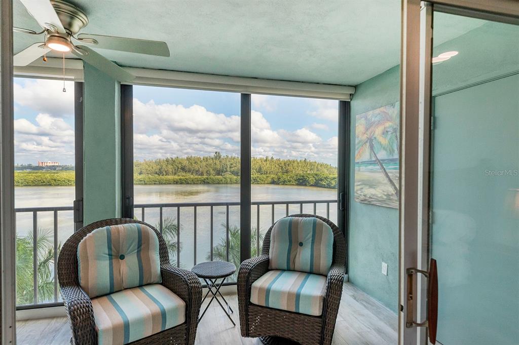 9397 Midnight Pass Road, Unit 501 Sarasota, FL 34242 - Photo 10 of 45 a balcony with chairs and a couch