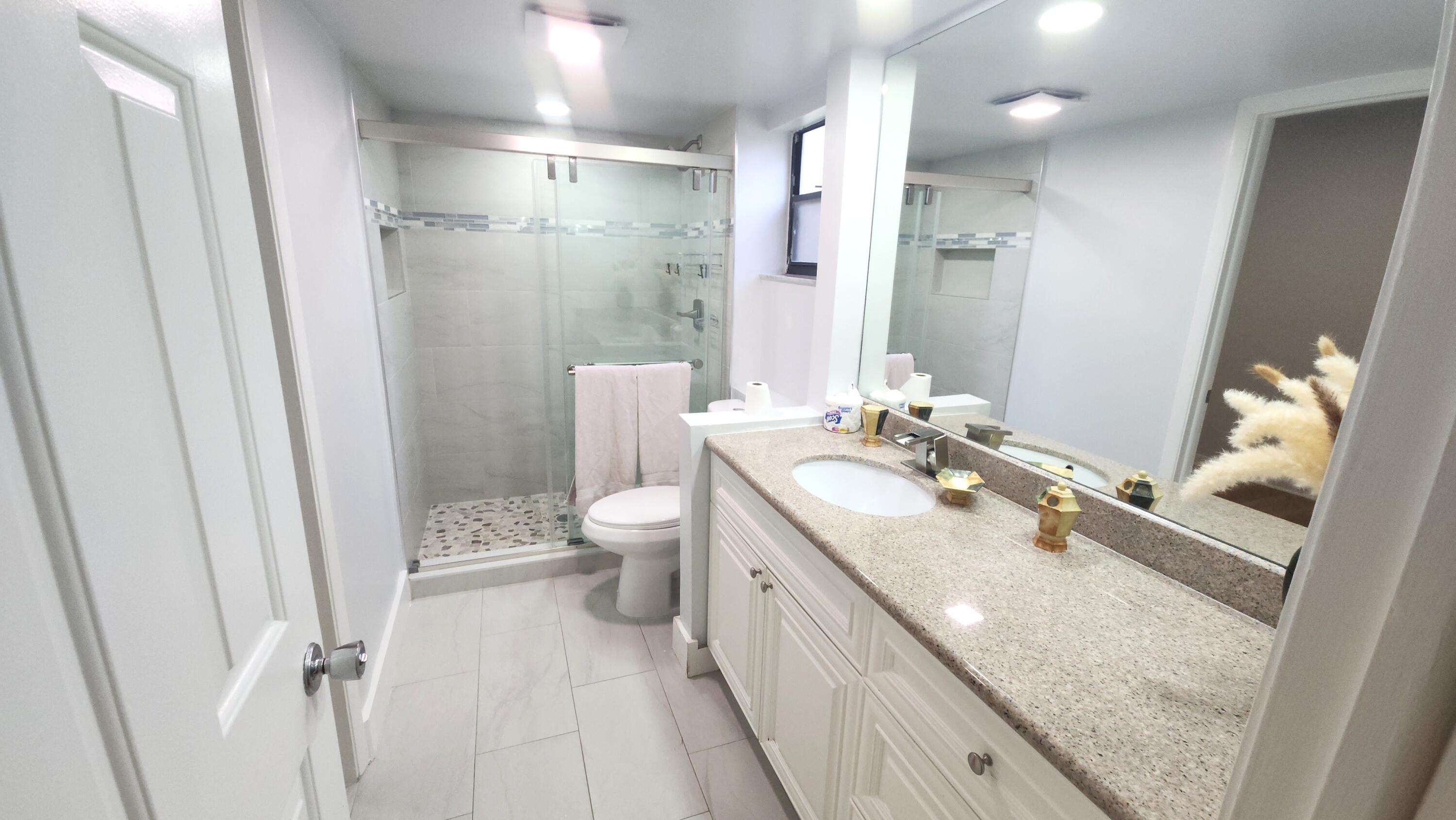 171 Deer Creek Boulevard, Unit 701 Deerfield Beach, FL 33442 - Photo 11 of 23 a spacious bathroom with a granite countertop sink toilet and shower