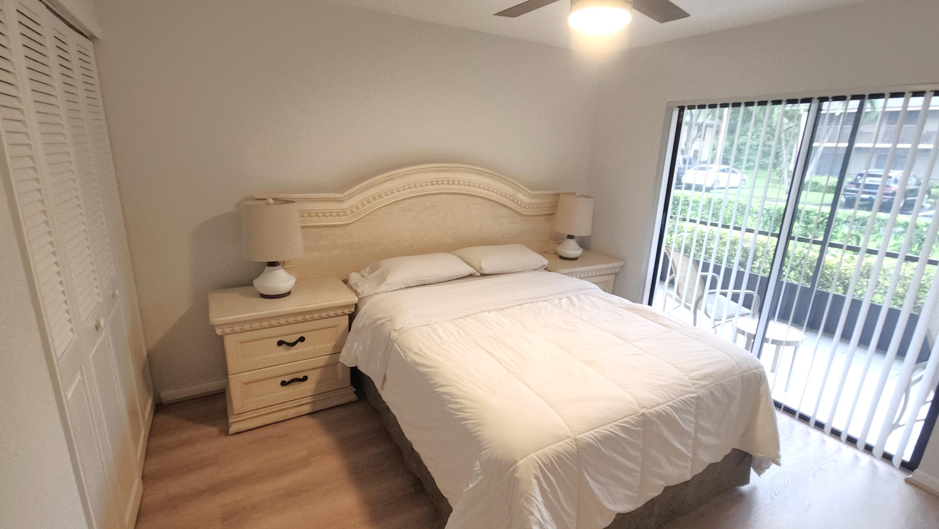 171 Deer Creek Boulevard, Unit 701 Deerfield Beach, FL 33442 - Photo 12 of 23 a bedroom with a bed and a chandelier