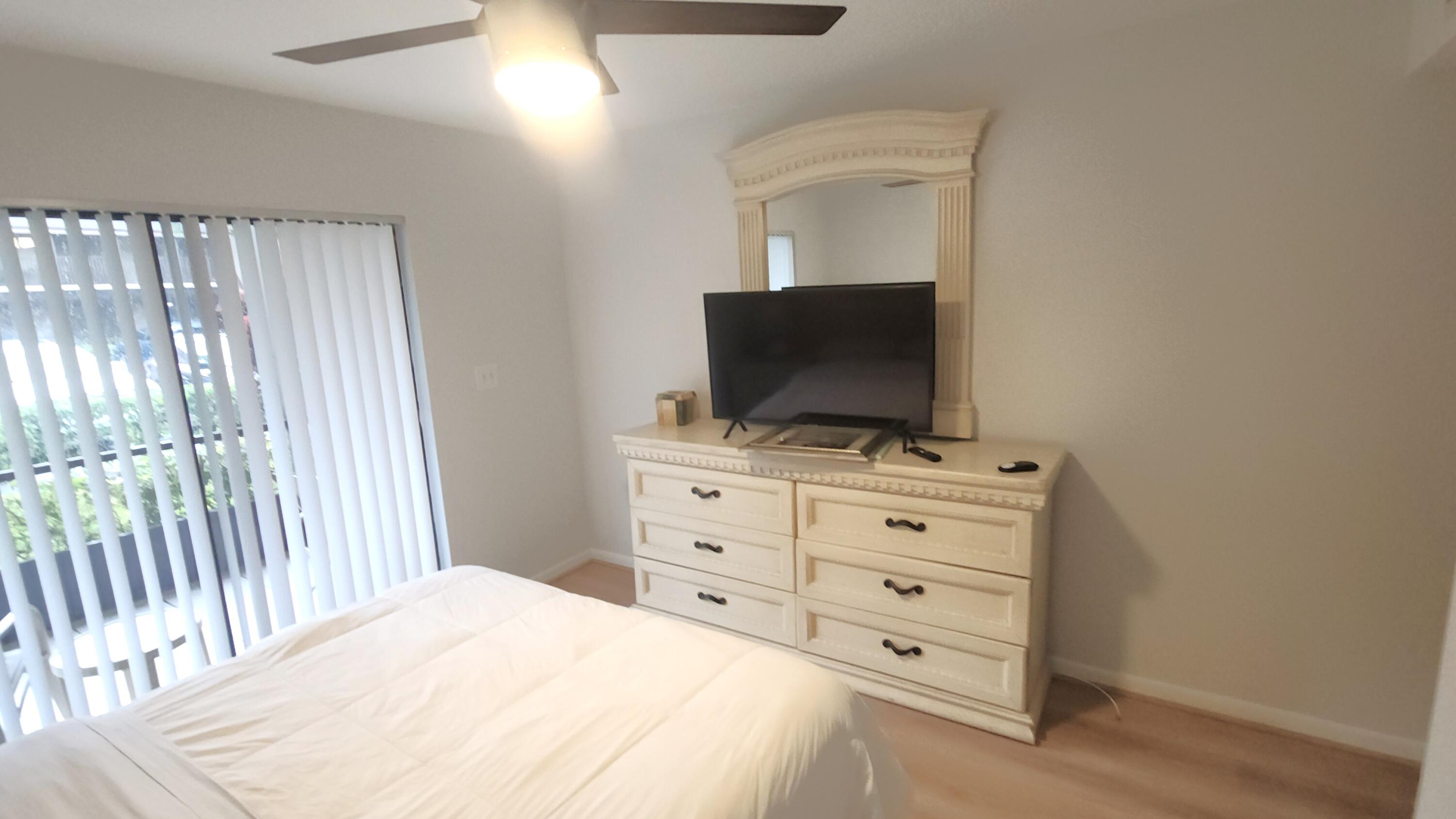 171 Deer Creek Boulevard, Unit 701 Deerfield Beach, FL 33442 - Photo 13 of 23 a bedroom with a bed and a flat screen tv