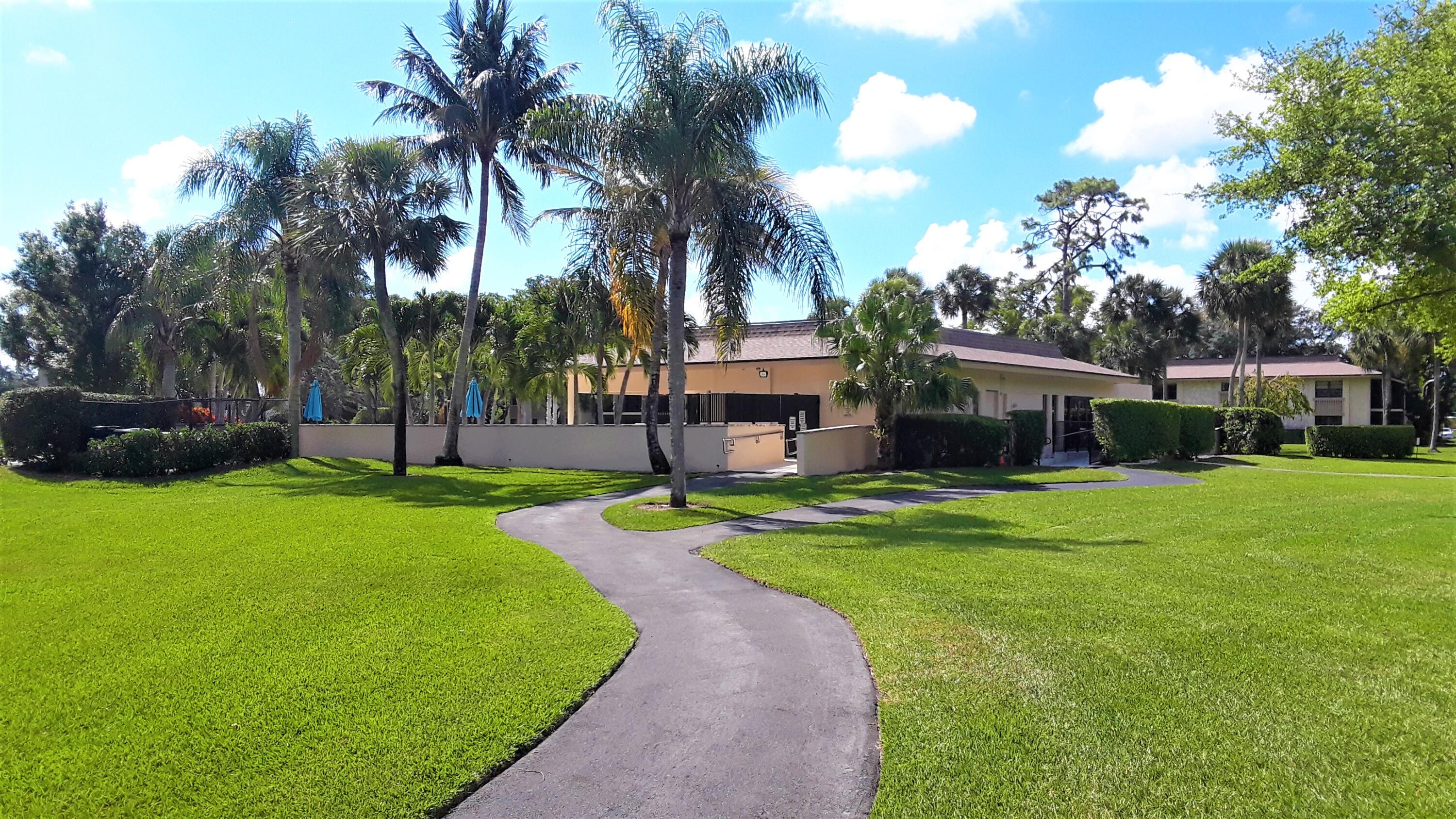 171 Deer Creek Boulevard, Unit 701 Deerfield Beach, FL 33442 - Photo 20 of 23 a front view of a house with a yard and garage