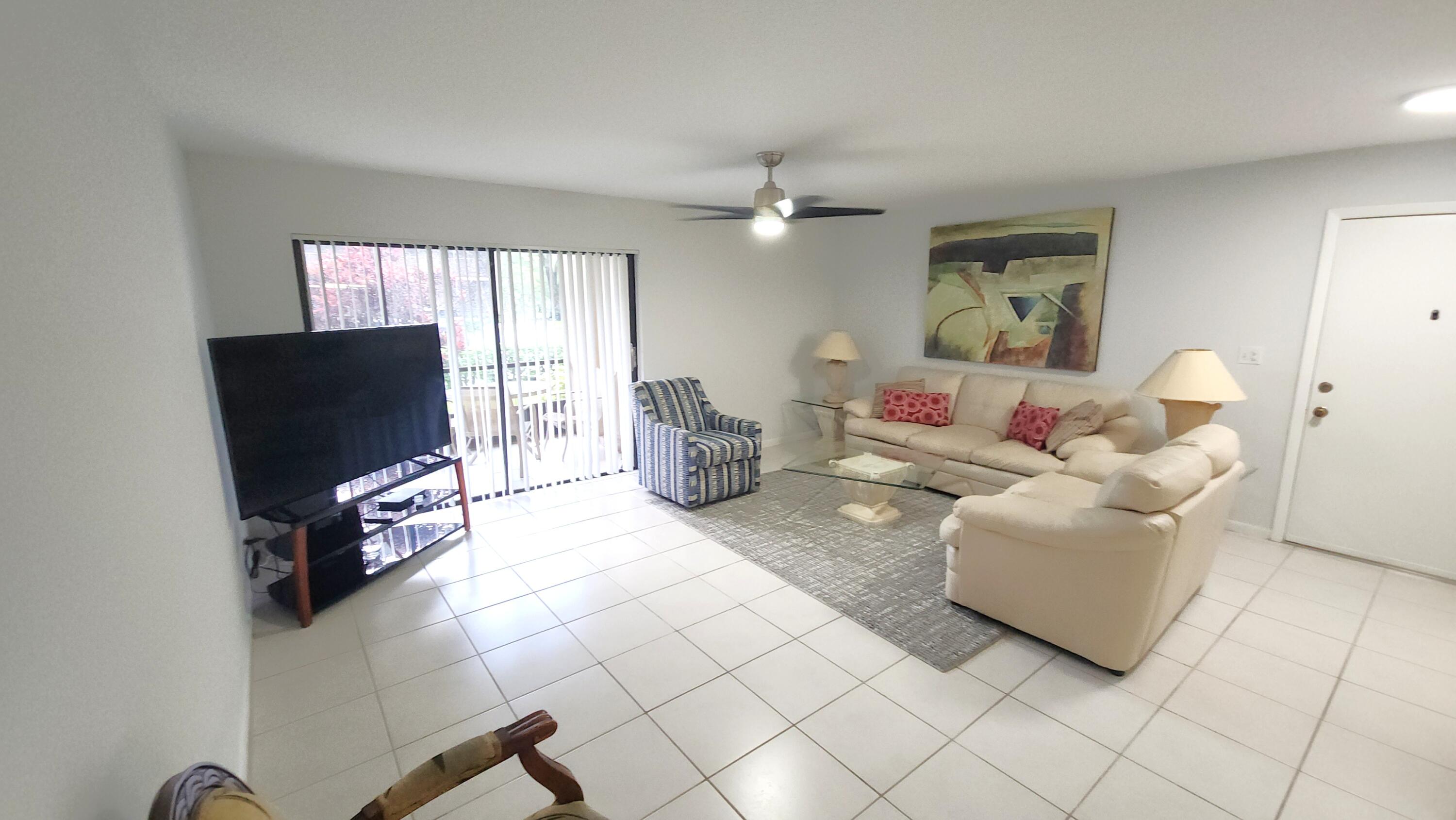 171 Deer Creek Boulevard, Unit 701 Deerfield Beach, FL 33442 - Photo 2 of 23 a living room with furniture and a flat screen tv