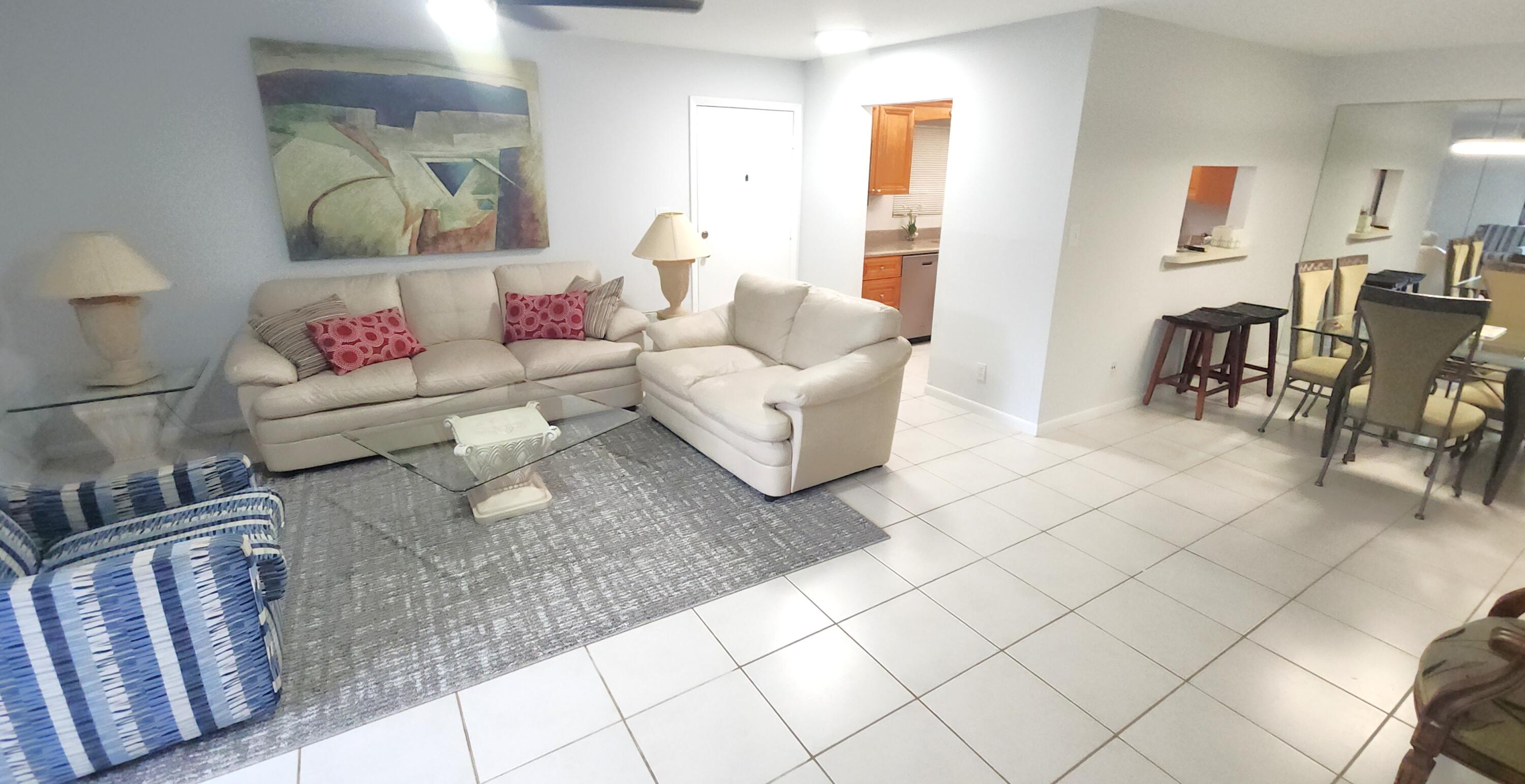 171 Deer Creek Boulevard, Unit 701 Deerfield Beach, FL 33442 - Photo 4 of 23 a living room with furniture and wooden floor