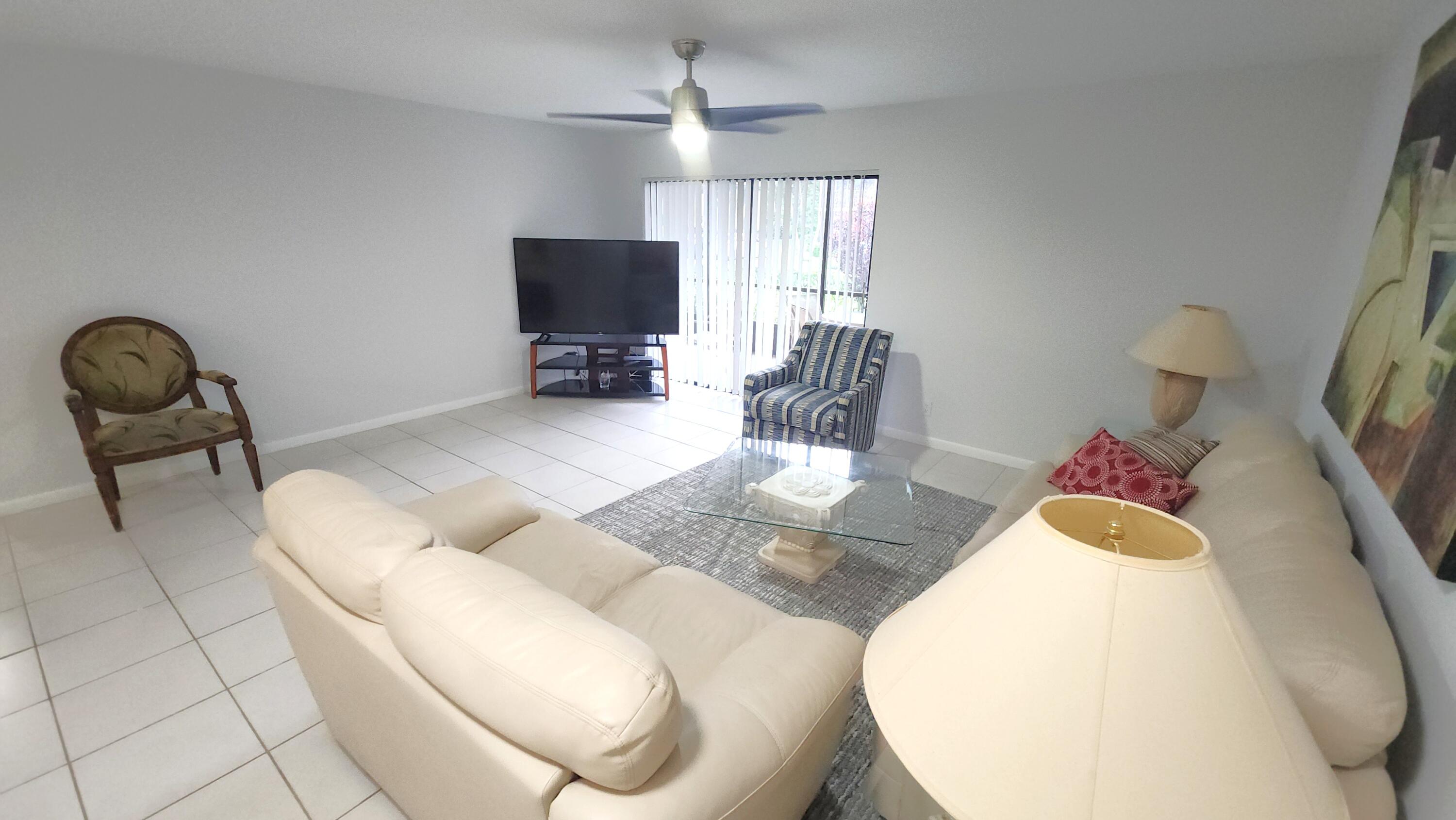 171 Deer Creek Boulevard, Unit 701 Deerfield Beach, FL 33442 - Photo 5 of 23 a living room with furniture and a flat screen tv