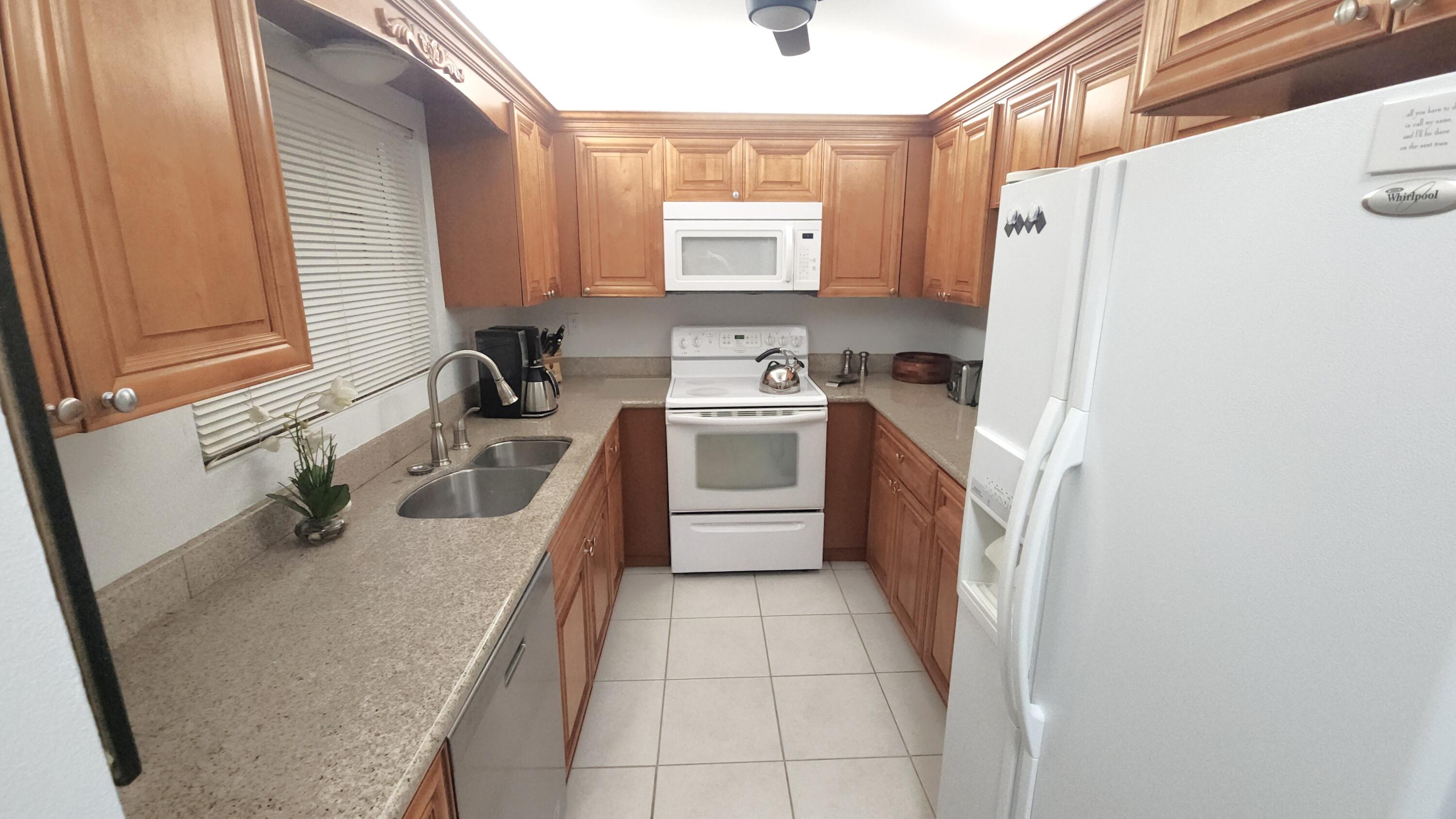171 Deer Creek Boulevard, Unit 701 Deerfield Beach, FL 33442 - Photo 7 of 23 a kitchen with a sink a stove a refrigerator and a window