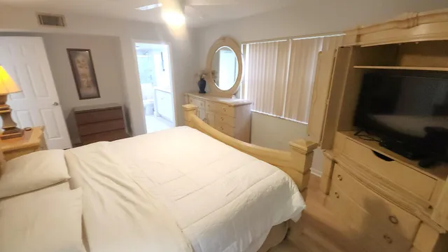a bedroom with a bed and a flat screen tv