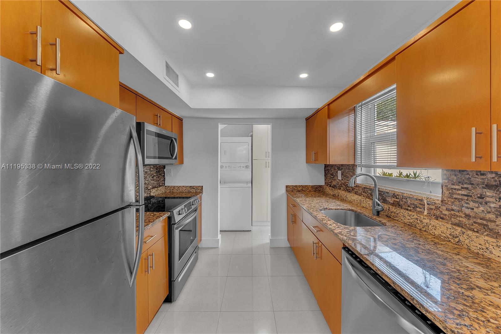 247 Bird Road Coral Gables, FL 33134 - Photo 11 of 22 a kitchen with granite countertop a sink stove and refrigerator