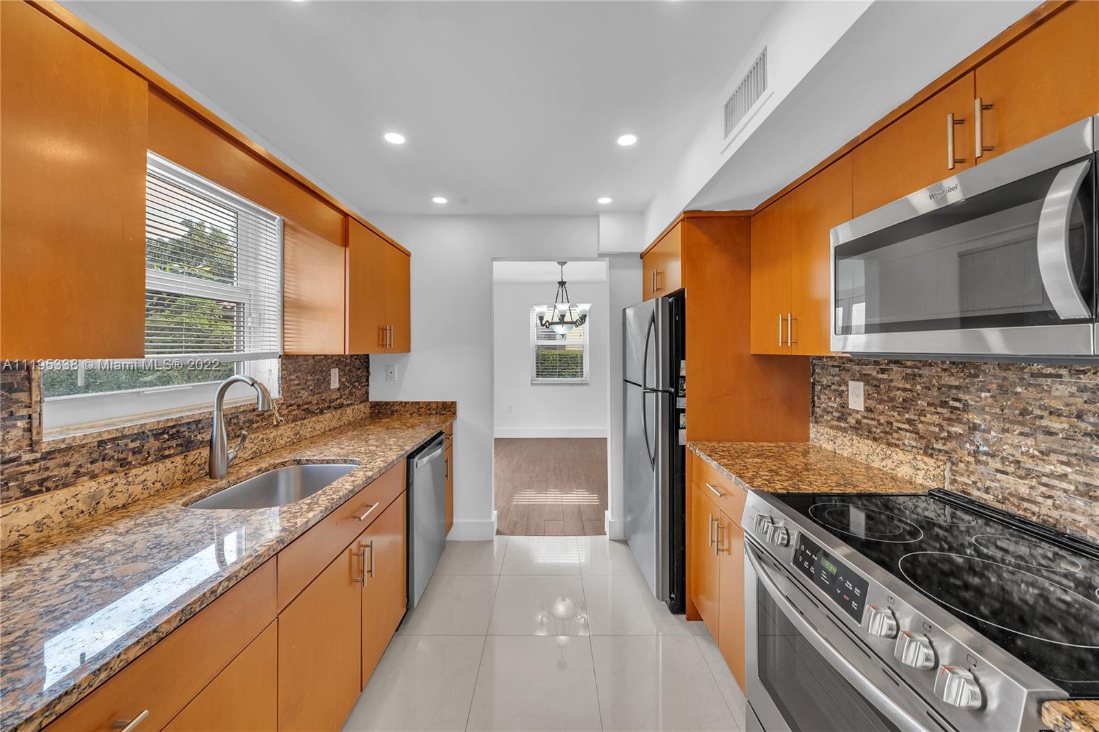 247 Bird Road Coral Gables, FL 33134 - Photo 12 of 22 a kitchen with stainless steel appliances granite countertop a sink stove and refrigerator