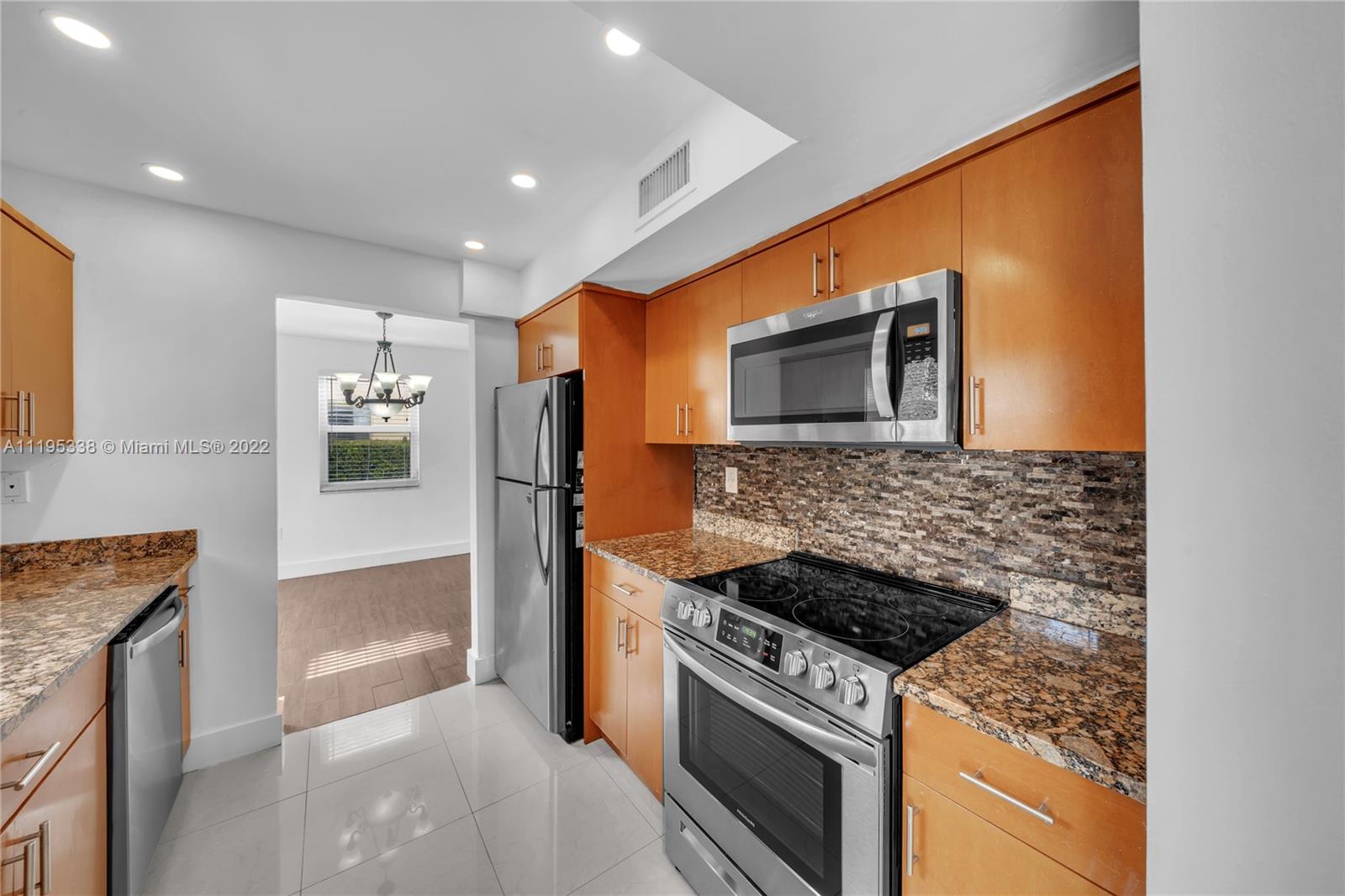 247 Bird Road Coral Gables, FL 33134 - Photo 13 of 22 a kitchen with stainless steel appliances granite countertop a stove and a refrigerator