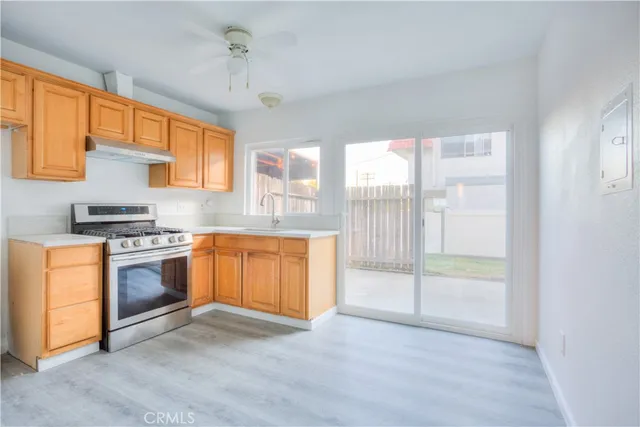 a kitchen with stainless steel appliances granite countertop a stove a sink and a refrigerator