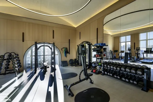 a living room with furniture gym equipment and a large window