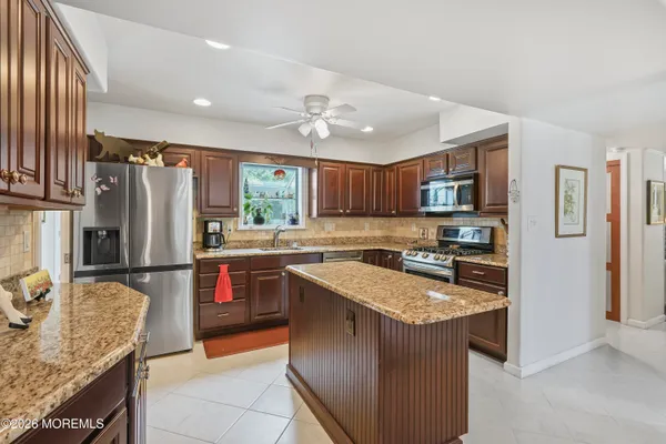 a kitchen with stainless steel appliances granite countertop a refrigerator stove microwave and sink