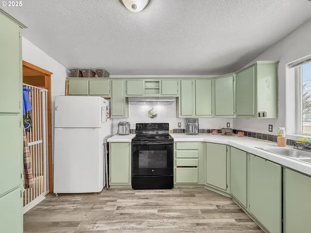a kitchen with a stove a refrigerator and a sink
