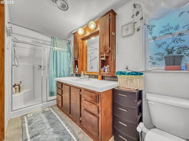 a bathroom with a granite countertop sink toilet and shower