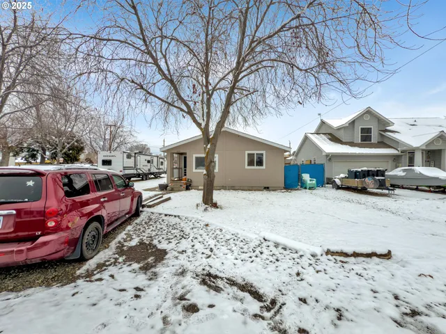 a front view of a house with cars parked